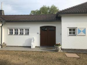 una piccola casa bianca con una porta marrone di Landhaus Sylvia a Eupen