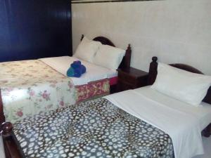 two beds in a hotel room with a teddy bear sitting on them at Beautiful Apartment at the beach of Taghazout in Taghazout