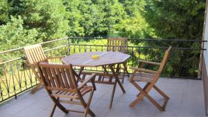 a wooden table and chairs on a balcony at Agroturystyka u Mańka in Suwałki