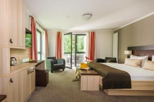 バート・ゾーデン・アレンドルフにあるRomantik Hotel Ahrenbergのベッドとデスクが備わるホテルルームです。