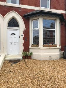 a white door on a red brick house at Blackpool Holiday Lets -GF Regent Road in Blackpool