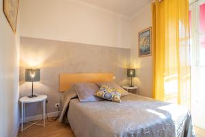 ein Schlafzimmer mit einem Bett mit zwei Lampen in der Unterkunft Hôtel Le Foch in Beaune
