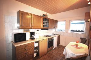 a small kitchen with wooden cabinets and a table with a table at Ferienwohnungen Kießler in Winterberg