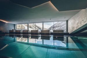 a swimming pool with chairs and a view of the mountains at Elizabeth Arthotel in Ischgl