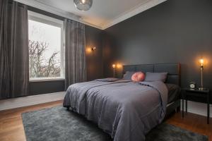 a bedroom with a bed and a large window at Sudurgata - Luxury Dream Apartment in Reykjavík