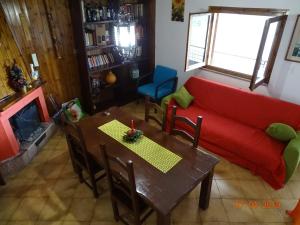 ein Wohnzimmer mit einem roten Sofa und einem Tisch in der Unterkunft Casa di Josè e Miriam in Piglio