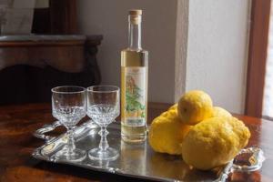 - une bouteille de vin et deux citrons sur une table avec des verres dans l'établissement Ca' de Capun, à Manarola