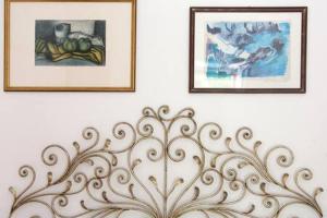 two framed pictures on a white wall with a bench at Ca' de Capun in Manarola