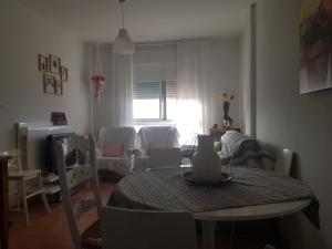 uma sala de estar com uma mesa e uma sala de estar com um sofá em Apartamento 2dorm Montaña y Playa em Enix
