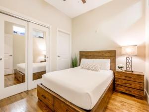 a bedroom with a large white bed and a mirror at Gorgeous Condos Steps from French Quarter and Harrah’s St. in New Orleans