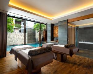 a bedroom with two beds and a swimming pool at Anantara Uluwatu Bali Resort in Uluwatu