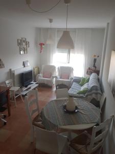 uma sala de estar com uma mesa e um sofá em Apartamento 2dorm Montaña y Playa em Enix