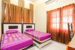 two twin beds in a room with a window at Trans Bandara Residence in Sungairampah