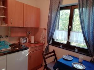 una piccola cucina con tavolo e finestra di Azúr apartman a Harkány