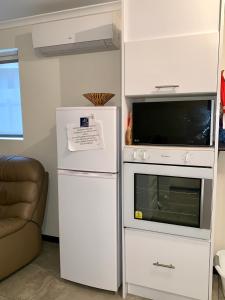 um frigorífico branco ao lado de um micro-ondas e um forno de micro-ondas em Inna Nutshell em Kingscote