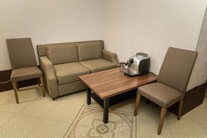 sala de estar con sofá, mesa y sillas en Boutique Hotel on Mukomolniy en Moscú