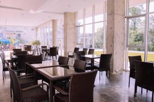a dining room with tables and chairs and windows at Hotel Nobilis Hall in K'obulet'i