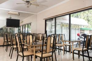 una fila de mesas y sillas en un restaurante en RedDoorz near Juanda International Airport en Surabaya