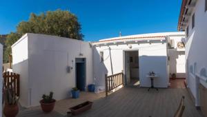 a large white building with a wooden deck at Cactus Room in Matala