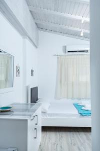 um quarto branco com uma cama e uma janela em Cactus Room em Matala