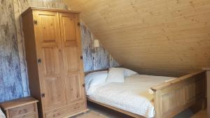 ein kleines Schlafzimmer mit einem Bett und einem Schrank in der Unterkunft Chata Starych Znajomych in Sanok
