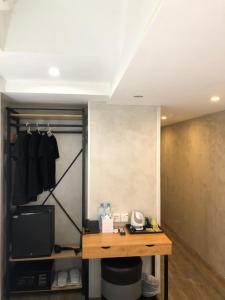 a room with a desk and a closet with a television at Homy Central in Hong Kong