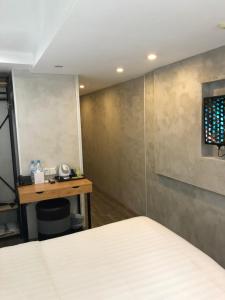 a room with a bed and a table and a wall at Homy Central in Hong Kong