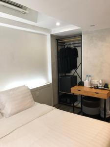 a bedroom with a bed and a desk and a closet at Homy Central in Hong Kong