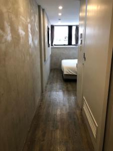a small hallway with a bed and a window at Homy Central in Hong Kong