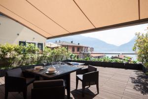 patio con mesa y sillas en el balcón en Terrazza sul Lago en Acquaseria
