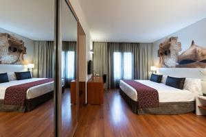 a hotel room with two beds and a mirror at Catalonia Gracia in Barcelona +22 photos