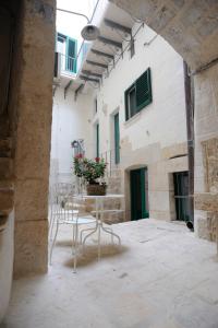 um pátio com cadeiras, uma mesa e um edifício em Il Nido dei Falchi B&B em Altamura