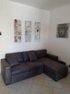 un divano in soggiorno con tre foto sul muro di Dolce Sogno 2 ad Alghero