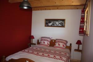 a bedroom with a bed with red walls at La Case in Abondance