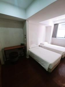 a hotel room with two beds and a window at Homy Central in Hong Kong
