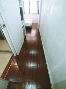 a hallway with a wooden floor and a window at Homy Central in Hong Kong