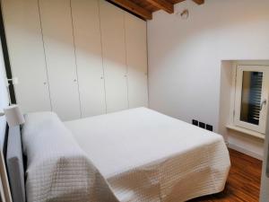 a bedroom with a white bed and a window at BellaGiò Apartment pool free parking near lake in Bellagio +31 photos