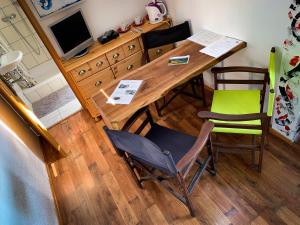 a wooden table with two chairs and a television at Guest House Lagotto's Peak in Radatovići