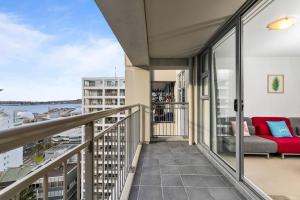 a balcony with a couch and a view of the water at Wonderful Apartment in Quiet CBD Neighbourhood! in Auckland