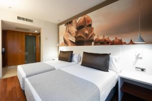 a hotel room with two beds and a painting on the wall at Catalonia Gracia in Barcelona
