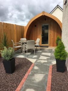 a patio with a table and chairs in front of a building at Portree Pod in Portree