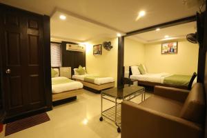 Habitación de hotel con 2 camas y sofá en Hotel Happyland, en Bombay