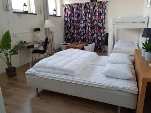 um quarto com uma cama com almofadas e uma secretária em Alkoven Logi em Ullared