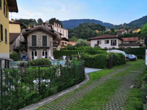 an old house in a village with a fence at BellaGiò Apartment pool free parking near lake in Bellagio