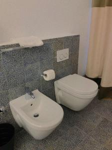 a bathroom with a white toilet and a sink at Torre Tresca 2 in Bari