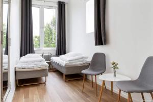a bedroom with two beds and a table and chairs at Alkoven Logi in Ullared