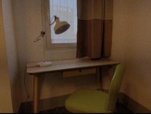 een bureau met een groene stoel en een lamp bij Torre Tresca 2 in Bari