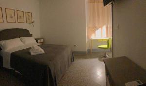 um quarto com uma cama, uma cadeira e uma secretária em Torre Tresca 2 em Bari