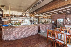 a bar in a restaurant with a brick wall at COLUMBUS Apartamenty Ustka - Limanowskiego 1 in Ustka