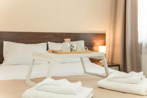 Una cama con una mesa blanca con toallas. en Boutique Hotel on Mukomolniy en Moscú